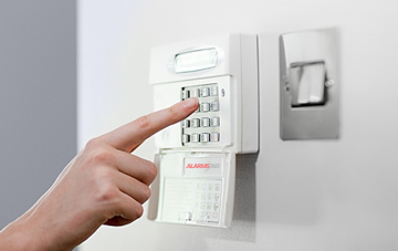 Person operating home security systems keypad